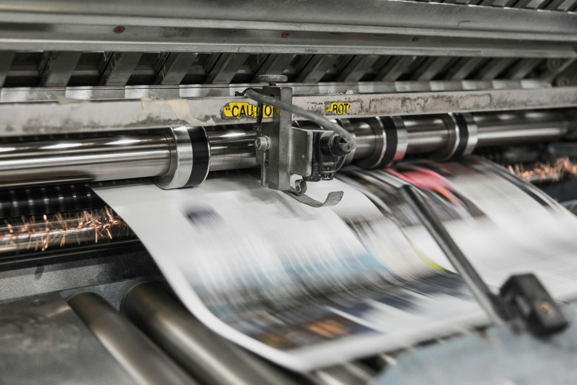 Newspapers running through a printing press at speed